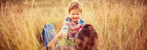 Niño jugando con padre en el campo